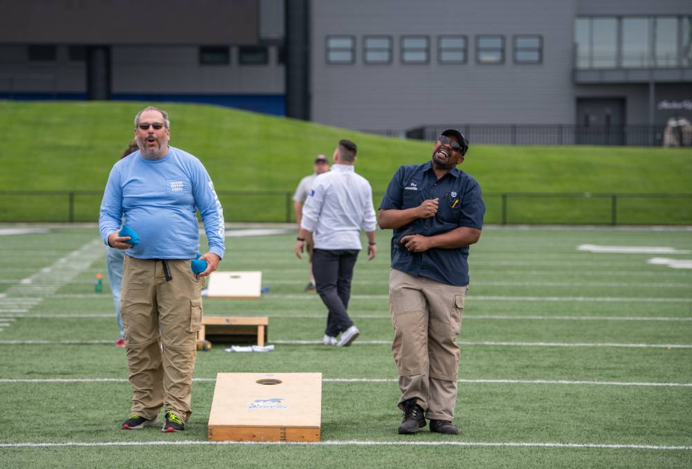Chad Covington looking regretful after his cornhole toss, while opponent appears both excited and surprised